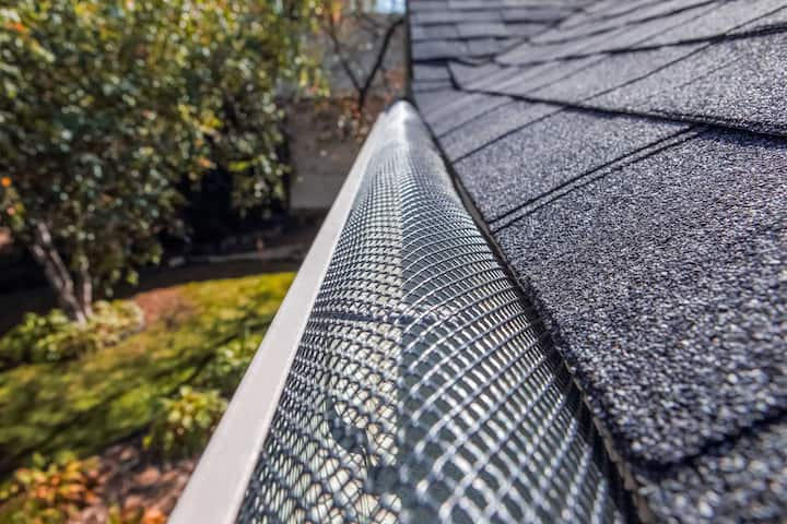 A contractor demonstrating the effectiveness of a gutter guard to a potential client in St Augustine